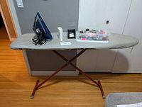 Ironing board with iron, fill cup, sewing kit on top
