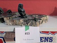 Full view of jade fisherman sculpture on slab base with label visible