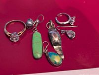 Mixed jewelry pieces displayed on pink surface