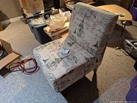 Front oblique view of the Paris-themed upholstered slipper chair showing fabric pattern and wooden legs