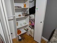 Closet shelves with bedding, cups, storage items