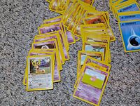 Spread of purple Psychic-type and yellow Fighting-type Pokémon cards on carpet