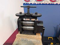 Front oblique view of rolling mill showing frame, rollers and gears