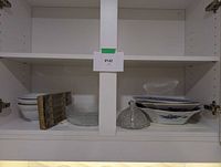 Full view of cupboard shelf displaying all items in lot