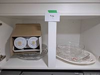 Shelf view showing boxed drink dispenser and multiple platters