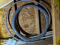 Overall view of large galvanized steel wire coil leaning against wall