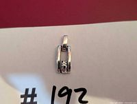 Front view of sterling silver pendant showing open rectangle design and white stone