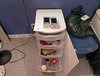 Overall lot with drawer cart, two iPhones on top, surrounding items visible