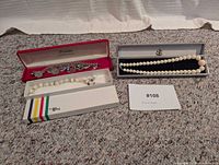 All three boxed jewellery items—bracelet and two necklaces—displayed together