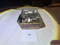 Tin container open showing quantity of coins