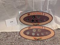 Both sealed oval coin sets displayed front view