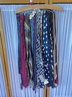 Front view of all neckties hanging on wooden hanger