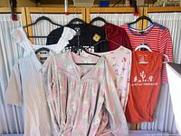 All eight tops hanging on partition showing overall lot contents