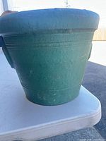 Side view of green terracotta planter showing color and shape