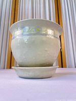 front view of off-white ceramic planter with attached saucer