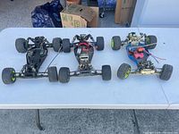 All three RC buggy chassis on table showing overall condition and included electronics