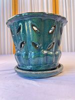 Exterior view of planter on saucer showing glaze color and cutouts