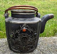 Front view showing dragon relief, multiple cabochons, copper-tone handle