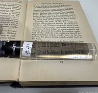 Bar magnifier on open book showing magnification effect and UltraOptix logo