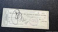 Front of 1934 British Columbia unemployment relief cheque showing amount, date, serial number, stamps and punch cancellations