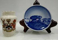 Front view showing milk glass vase with Penkridge crest beside Royal Copenhagen blue plate on stand