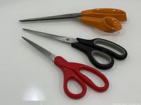 Three scissors laid out showing size and handle colors