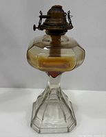 Full view of glass kerosene lamp showing pedestal base and octagonal font
