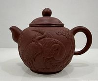 Right-side view of teapot showing relief cranes and handle