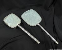 Mirror and brush backs showing brocade and handles