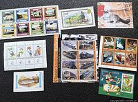 All eight stamp sheets and singles spread on black surface