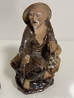 Front view of Shiwan fisherman figurine showing facial expression, fish and overall form