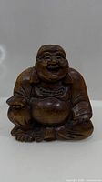 Front view of wooden Laughing Buddha figurine