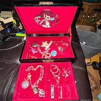 open jewelry box showing assorted jewelry pieces