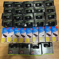 Top view showing five rows of boxed dummy cameras, mix of black and blue packaging