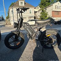 Left side view of entire e-bike showing frame, tires, suspension fork, and accessories
