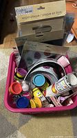 Overview of bin with wood plaque pack, iron-on art packs, Play-Doh tubs and accessories