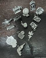 All pewter charms grouped together on dark surface