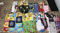 Full spread of roughly 50 new tagged novelty crew socks showing multiple licensed designs