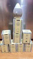 Stack of eight boxed diffusers with one unboxed unit on top