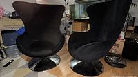 Front view of both black fabric swivel armchairs showing overall design and bases