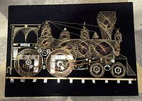 Full view of string art locomotive on black panel