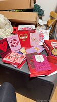 Bundles of assorted Valentine’s Day cards and red envelopes on ottoman
