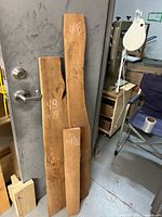 Three cherry boards leaning against a door, size markings visible