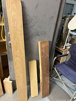Three hardwood boards (ash, poplar, walnut) with dimensions chalked on faces