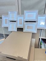 Front view showing seven whitewashed frames and mat openings