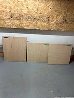 Three birch plywood panels leaning against wall