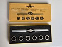 Full set in open box showing handle and six dies
