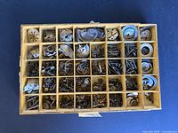 Top-down view of entire compartmented tray filled with assorted watch parts