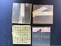 Four plastic trays containing watch balance wheels
