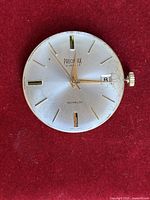 Front view of Precimax movement showing dial, hands, markers, and date window